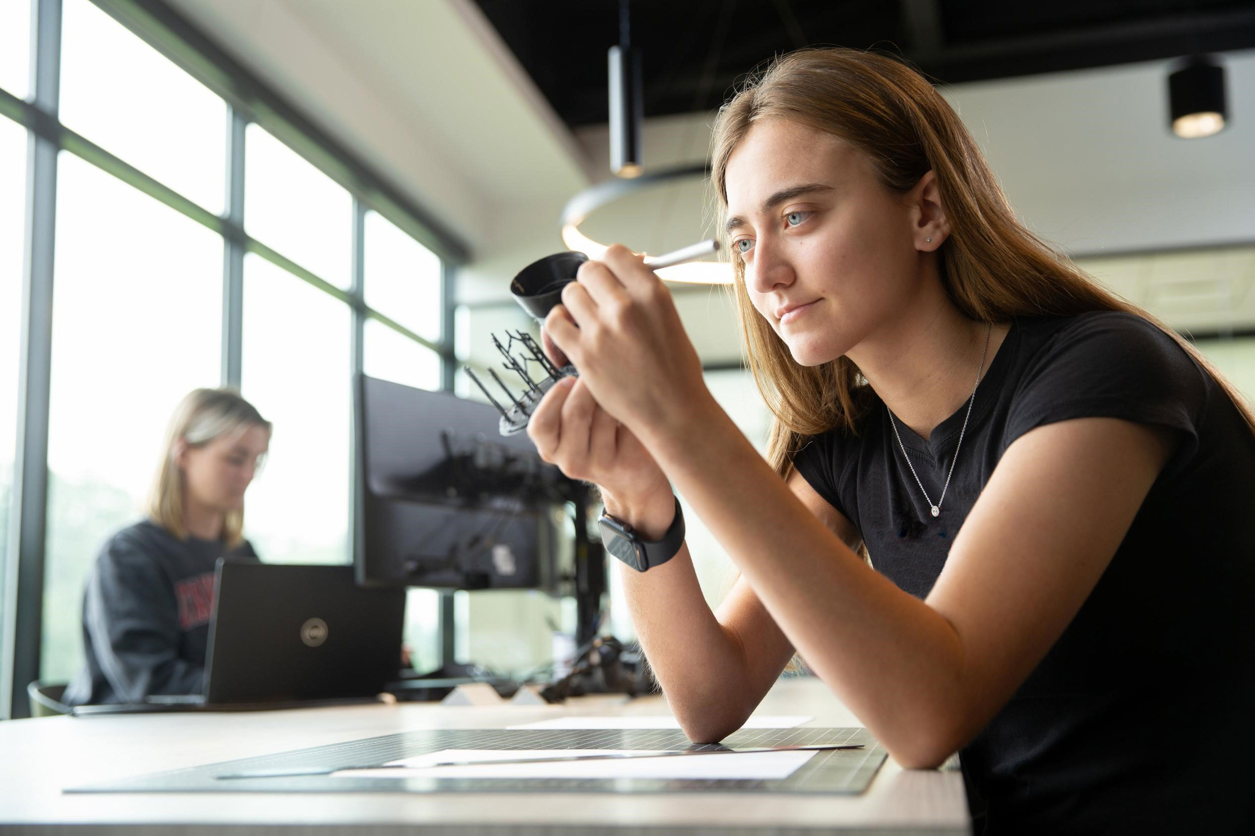 A University of Cincinnati co-op student inspects her 3D printed model